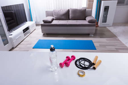 Elevated View Of Skipping Rope With Pink Dumbbells And Measurement Tape On White Deskの写真素材