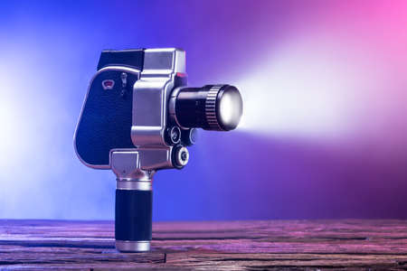 Close-up Of An Illuminated Movie Camera On Wooden Deskの写真素材