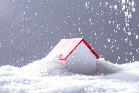 Close-up Of Snow Falling On House With Red Roof In Winterの写真素材