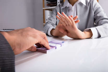 Close-up Of A Person's Hand Refusing Bribe From Partnerの写真素材