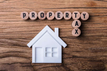 Elevated View Of House Model Near Blocks With Property And Tax Text On Wooden Backgroundの写真素材