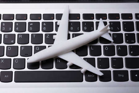 Elevated View Of White Airplane Miniature On Laptop Keypadの写真素材