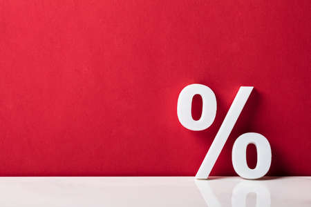 Close-up Of A Percentage Sign Leaning On Red Wallの写真素材