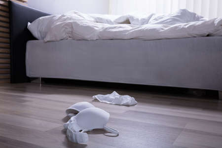 White Scattered Lingerie On Hardwood Floor In Bedroomの写真素材