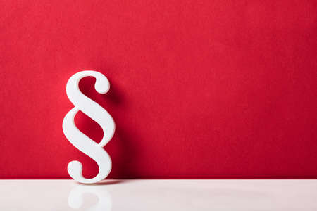 Close-up Of A Paragraph Symbol Leaning On Red Wallの写真素材