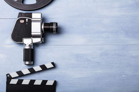 High Angle View Of Movie Camera With Film Reel And Clapper Board On Wooden Plankの写真素材