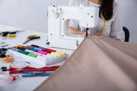 Fashion Designer Working On Sewing Machine Stitching A Long Length Fabricの写真素材