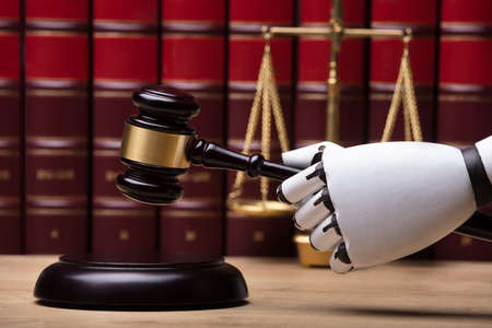 Close-up Of A Robotic Hand Striking Gavel On Sounding Block In Courtroom