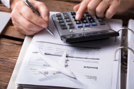Close-up Of A White Aeroplane In Front Of Businessperson Calculating Invoiceの写真素材