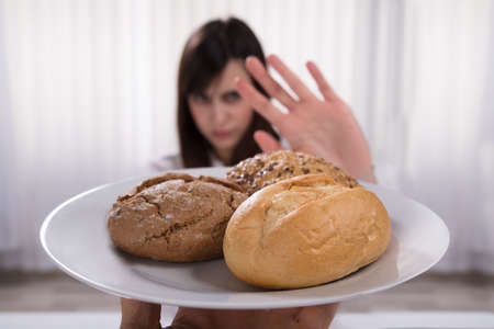 Woman Refusing Plate Of Bread And Cookies Offered By A Person