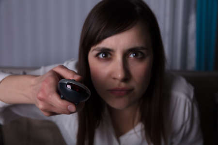 Close-up Of A Young Woman Holding Remote Controlの写真素材