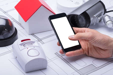 Architect's Hand Using Mobile Phone With Blank White Screenの写真素材