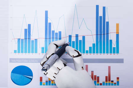 Close-up Of A Robotic Hand Using Pen While Working On Graphの写真素材