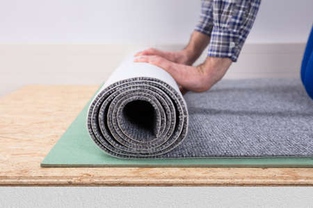 Close-up Of A Male Worker's Hand Installing Carpetの写真素材