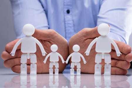 Close-up Of A Person's Hand Protecting Family Human Figures