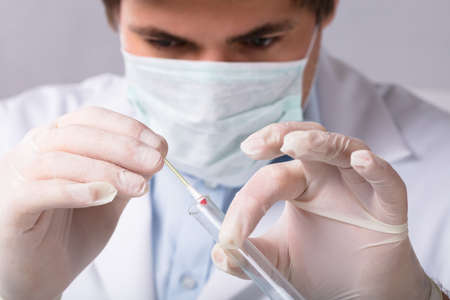 Close-up Of A Forensic Expert Taking Blood Sample With Cotton Swab