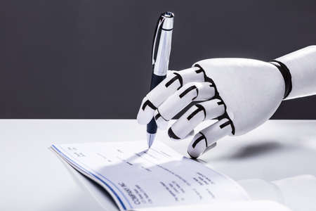 Photo Of Robot Hand Signing Cheque With Penの写真素材