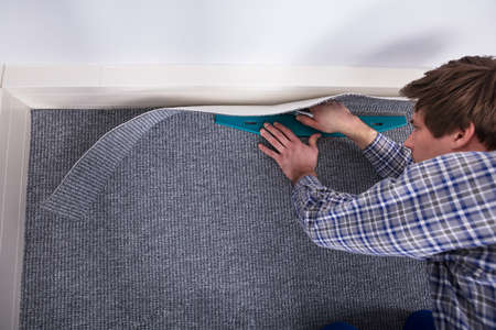 Male Carpet Fitter Installing Carpet With Cutterの写真素材