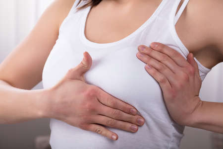 Close-up Of A Woman's Hand On Breast Showing Cancer Symptomの写真素材