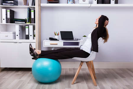 Side View Of A Relaxed Businesswoman Stretching Her Armsの写真素材