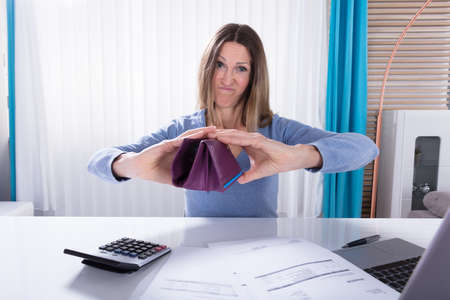 Unhappy Mature Woman Shows Her Empty Purse In Office