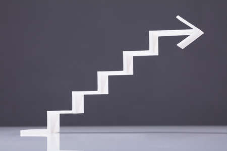 White Increasing Staircase Arrow On Grey Backdrop