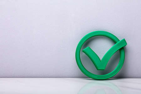 3d Green Check Mark Icon In Front Of Wallの写真素材
