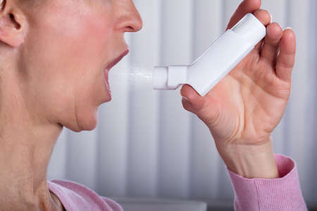 Close-up Photo Of Woman Using Asthma Inhalerの写真素材