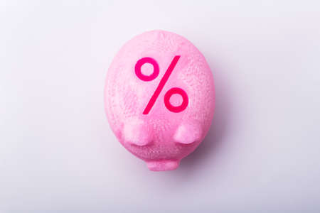 Over Head View Of A Red Percentage Sign On Pink Piggy Bankの写真素材
