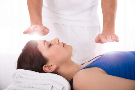 Close-up Of A Relaxed Young Woman Having Reiki Healing Treatmentの写真素材