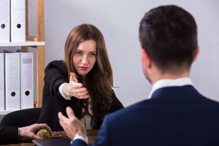 Two Young Businesspeople Having Conversation At Workplaceの写真素材
