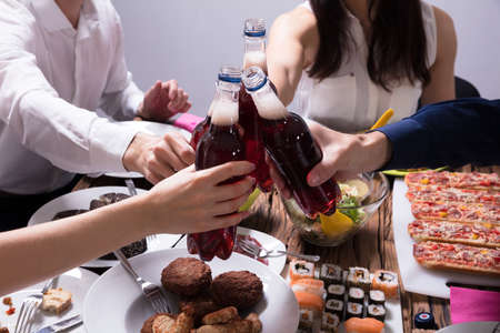 Group Of Happy Young Friends Celebrating With Bottle Of Lemonade Drinkの写真素材