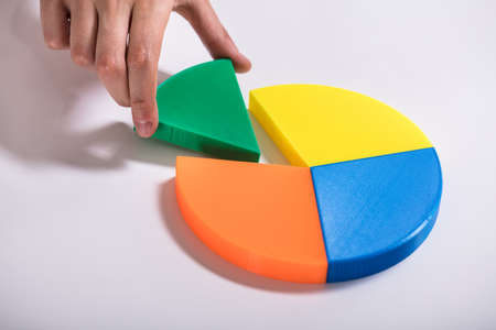 High Angle View Of Businessperson's Hand Placing Last Piece Into Pie Chartの写真素材