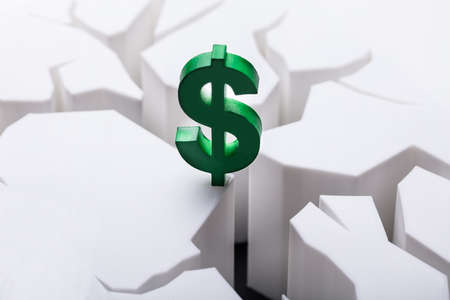 Close-up Of Green Dollar Currency Sign On Damaged White Surfaceの写真素材