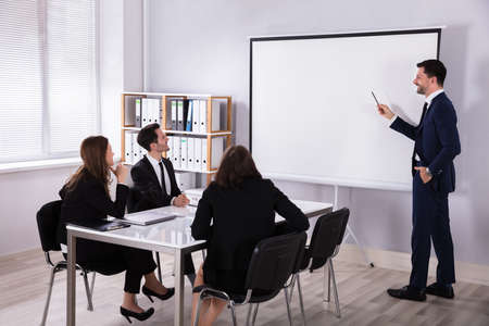 Young Businessman Giving Presentation To His Colleague In Meeting