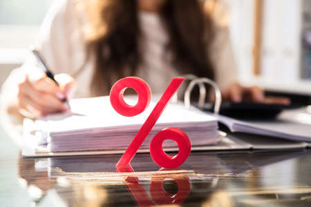 Close-up Of Percentage Symbol In Front Of Businessperson Working On Documentの写真素材