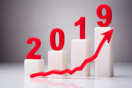 Year 2019 With Increasing Arrow Against Gray Background