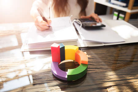 Multi Colored 3d Pie Chart In Front Of Businessperson Working At Workplace