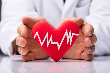 Human Hand Protecting Heart With Heartbeat Isolated On White Background