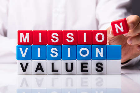 Person Building Colorful Cubic Blocks With Mission, Vision And Values Wordsの写真素材