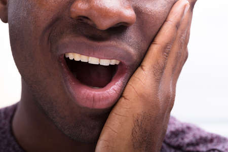 Close-up Of A Man Having Toothache Against White Background