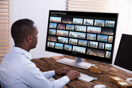 Close-up Of A Male Photo Editor Editing Images On Computer At Workplace