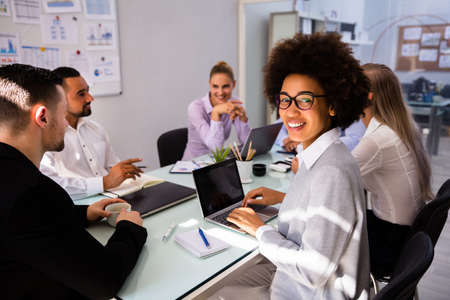 Portrait Of A Smiling African Businesswoman Working On Laptop