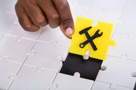 A Person's Hand Holding A Piece Of Yellow Work Tool Jigsaw Puzzleの写真素材