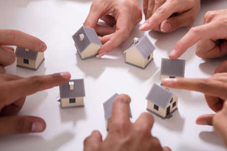 Group Of People Touching Miniature House On White Backgroundの写真素材