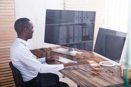 Happy Young Businessman Using Computers In The Officeの写真素材
