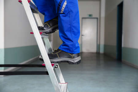 Low Section View Of A Handyman's Foot Climbing Ladder