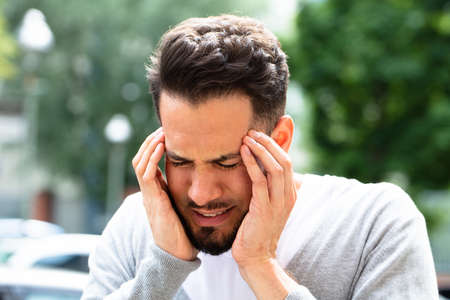 Close-up Of A Young Man Suffering From Headacheの写真素材