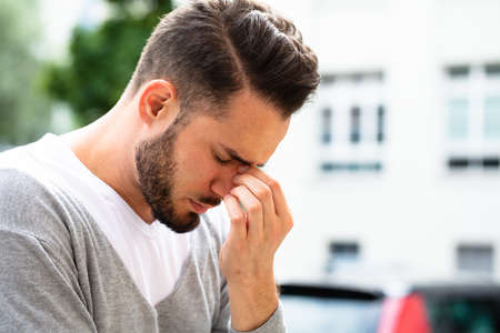 Close-up Of A Young Man Suffering From Headacheの写真素材
