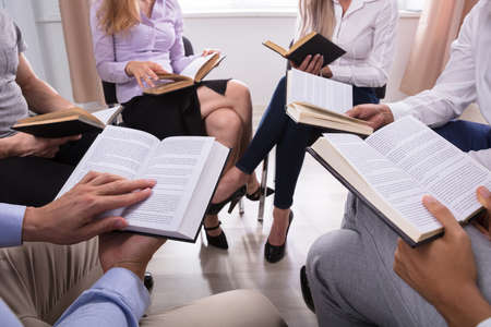Group Of People Sitting In A Circle Reading Holy Books